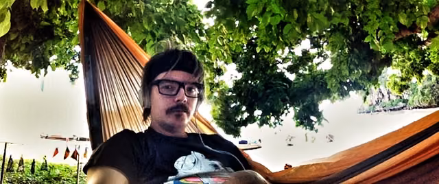 A wide selfie in a hammock under a tree