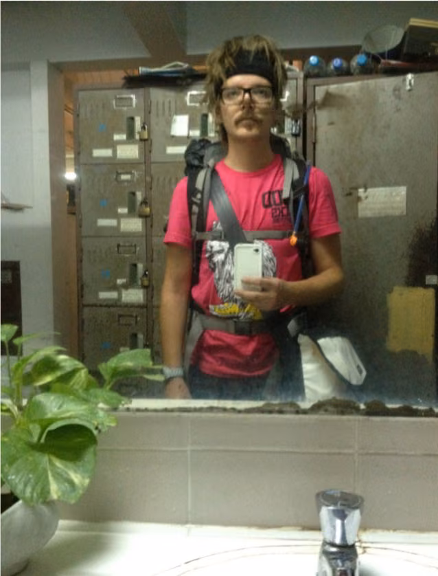 A mirror selfie in a pink tee, the backpack on